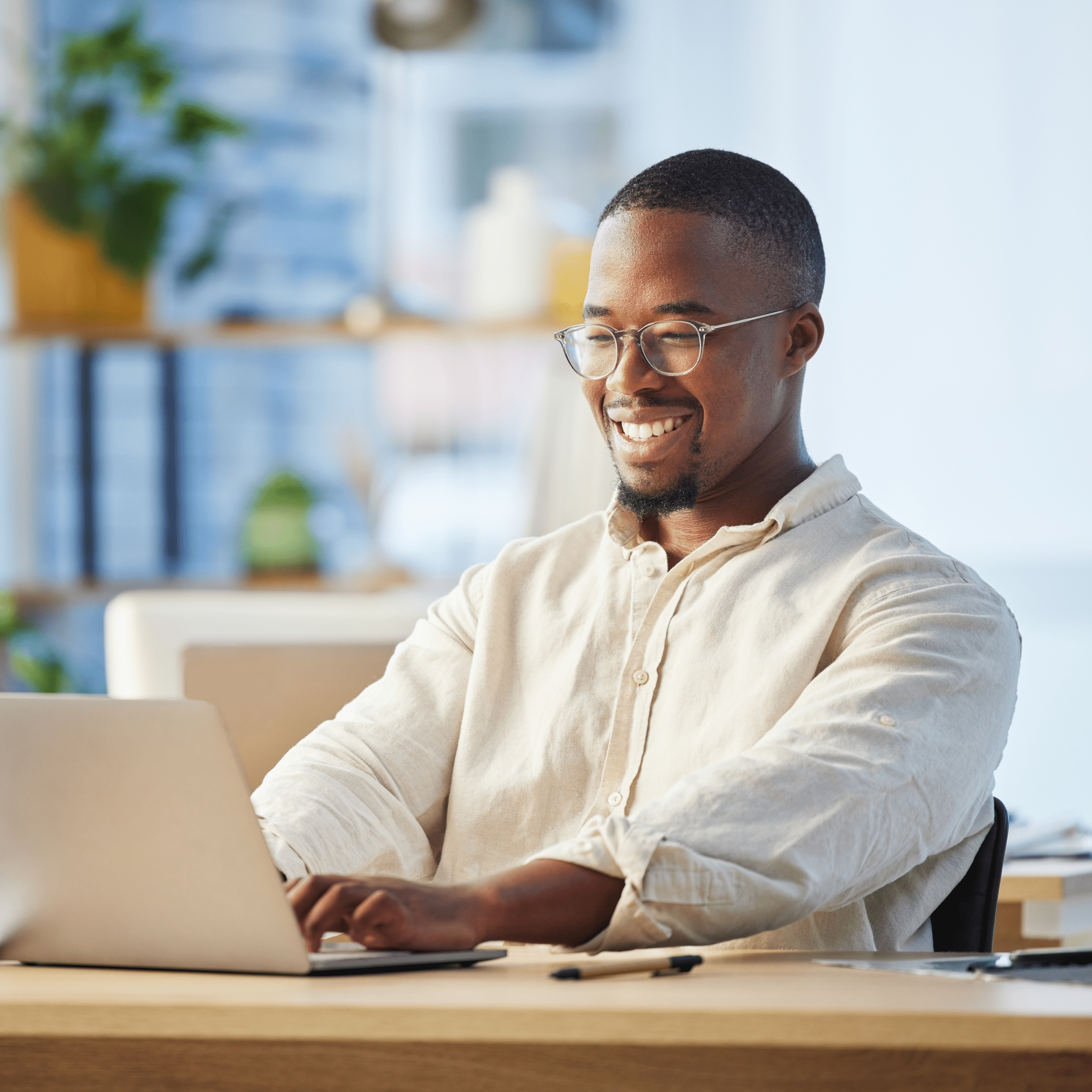 Man at a desk typing on a laptop