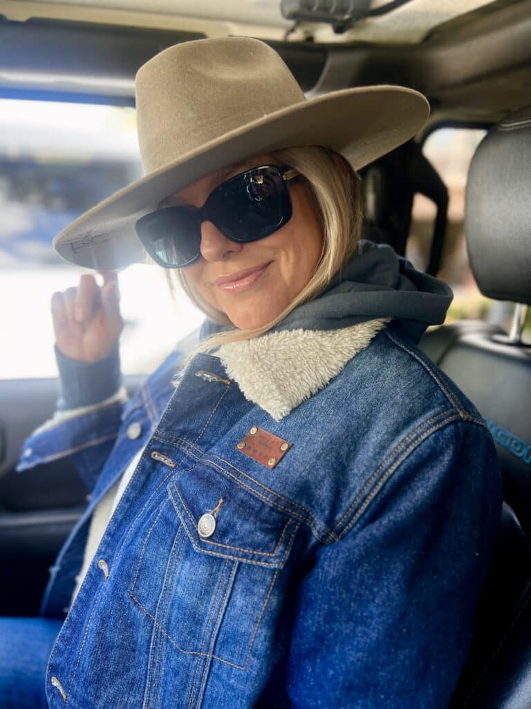 Woman wearing denim jacket with Live Taloha patch tag on it